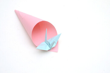 Cone paper on origami bird over white
