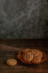 Oatmeal cookies on a dark wooden background with crumbs
