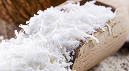 Vintage wooden spoon, grated coconut, shavings and coconut flakes, culinary ingredient for sweets and desserts, MACRO PHOTOGRAPHY