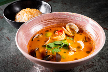 pan asian food. Tom Yum soup in bowl on table background
