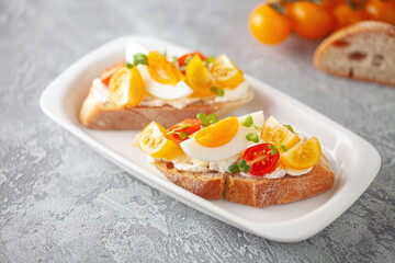 Open sandwiches with egg and tomatoes in a plate on the table