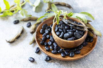 Organic food.  The concept of vegan or diet food. Fresh ripe black soy beans on a stone background.