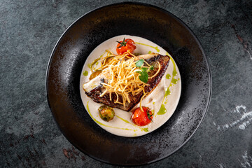 Fried fillet dorado fish with tomatoes, lemon and sauce on plate