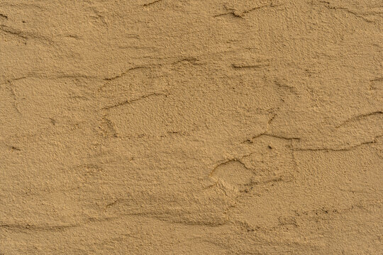 Old traditional house wall texture. Brown beige sandy color rough plaster background.