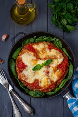 Meatzza. Fresh homemade crustless pizza made with ground meat crust instead of bread and topped with tomato sause, mozzarella cheese and fresh basil. Selective focus, vertical, dark wooden table.