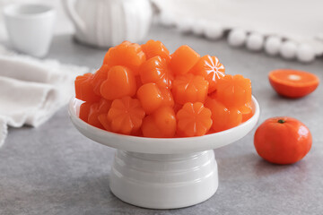Tangerine Jellies served on white ceramic cake stand. Homemade bright orange coloured candy gummies...