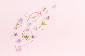 Floral pattern with wildflowers, green leaves, branch on pink background. Flat lay