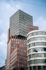 Modern tall office buildings exterior in the city agaist cloudy sky.