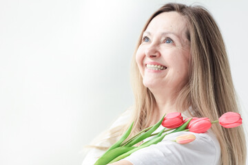 International Women's Day. Extremely happy woman is smelling a bunch of spring flowers. holiday, Mother's Day, Copy space