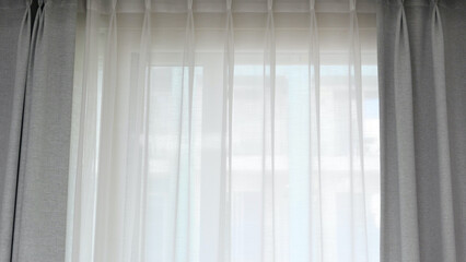 Voile curtain in front of window with grey curtains to either side