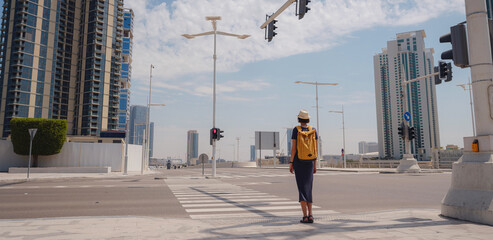 travel to the United Arab Emirates, Happy young asian female traveler with backpack and hat stands...