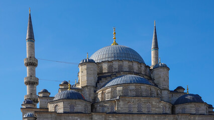 Obraz premium Architectural details of Yeni Cami or New Mosque. The dome of the New Mosque on the Galata Bridge on the Golden Horn in the Eminonu district in Istanbul Turkey