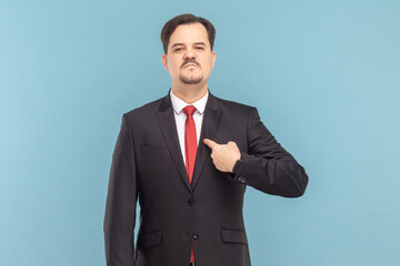 Proud self confident man with mustache standing pointing at himself, looking at camera with serious...