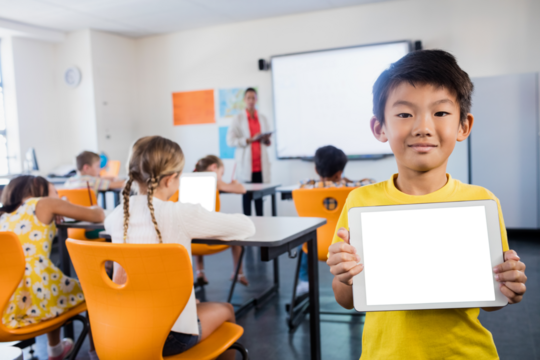 Young boy holding digital tablet while standing