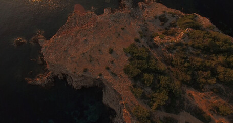 Naklejka premium Rock formation by sea during sunset