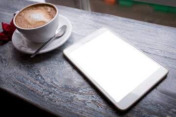Cappuccino and digital tablet on table