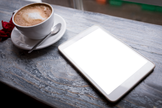 Cappuccino and digital tablet on table
