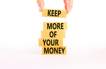 Keep more of your money symbol. Concept words Keep more of your money on wooden block. Beautiful white table white background. Businessman hand. Business keep more of your money concept. Copy space.