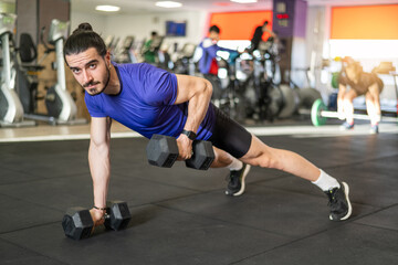 Fototapeta na wymiar Workout And Dumbbell Push Up At Gym For Muscle, Power Or Strength. Young Athlete Man Exercises And Trains His Body To Keep Fit And Lead A Healthy Life