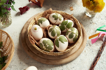 Easter eggs ready to be dyed with onion peels with a pattern of fresh plants