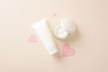 Indulge in luxurious skin care with top view flat lay of pump bottles and pink hearts on a soothing pastel beige background