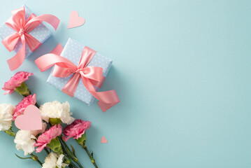 Top flat lay photo of beautiful present boxes with pink ribbon, carnation flowers with pink paper...