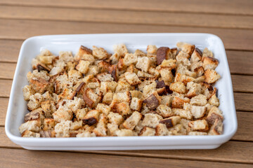 Crispy cubes of bread, croutons of white bread for cream soups. crackers on a white plate of wheat bread with olive oil and garlic. Recycling zero waste concept