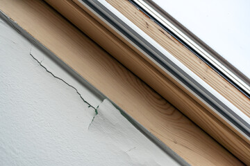 Cracked painted wall under the roof window in the bathroom. Paint peels off the wall. Falling paint chips. Peeling paint. Blistering paint