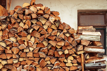 Background of stacked chopped wood logs. Pile of wood logs ready for winter. Wooden stumps, firewood stacked in heap