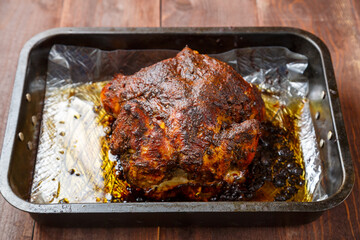Whole chicken baked in sauce and spices brown crust on a baking sheet.