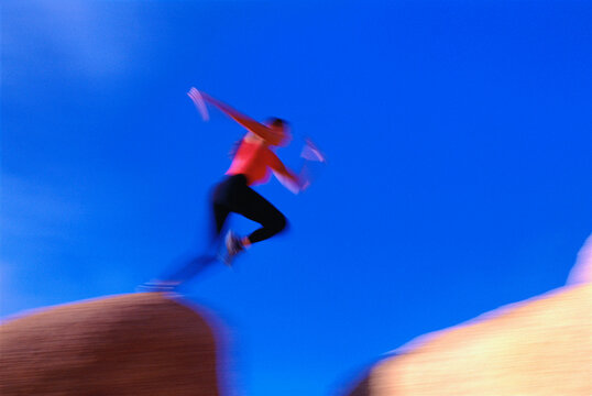 Blurred View of Woman Jumping Over Gap Joshua Tree, California, USA