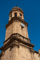 Fototapeta na wymiar Iglesia de la Purificación - Iglesuela del Cid - Torre campanario sobre cielo azul