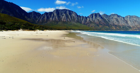 Scenic view of beach and sea by mountains 