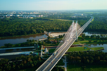 Aerial drone view of Redzinski bridge over Odra river in Wroclaw city, Poland. Large cable stayed bridge with car traffic in european city, bird eye view. Transportation infrastructure and logistic