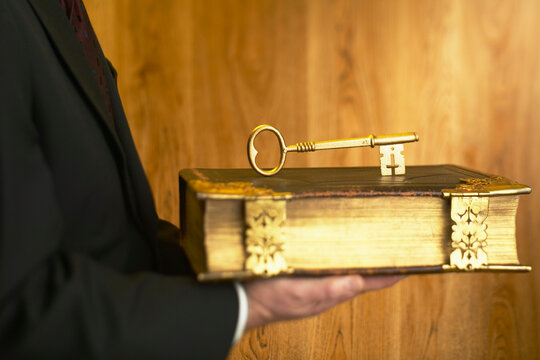 Man Holding Antique Book and Key