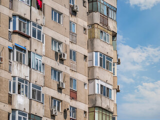 Worn out apartment building from the communist era against blue sky in Bucharest Romania. Ugly traditional communist housing ensemble