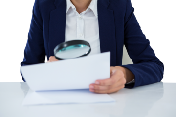 Businesswoman looking at document through magnifying glass
