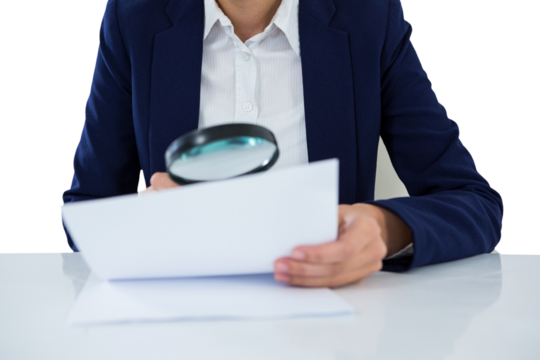 Businesswoman looking at document through magnifying glass