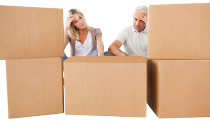 Tired couple sitting behind cardboard boxes