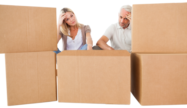 Tired couple sitting behind cardboard boxes