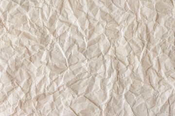 Recycled crumpled beige paper texture background. Wrinkled and creased abstract backdrop, wallpaper with copy space, top view.