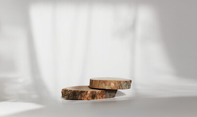 Wooden eco rustic pine tree wood circle disc platform podium on white light and shadow copy spase background. Minimal empty display product presentation scene.