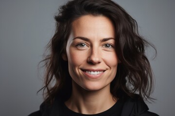 Fototapeta premium Portrait of a smiling woman looking at the camera over gray background