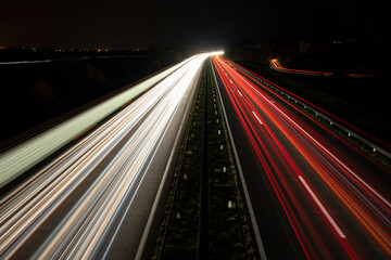 Red and white bright lights on the road. Night on the highway.