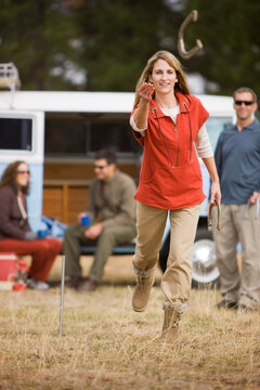 Woman Tossing Horseshoes While on a Camping Trip, Bend, Oregon, USA