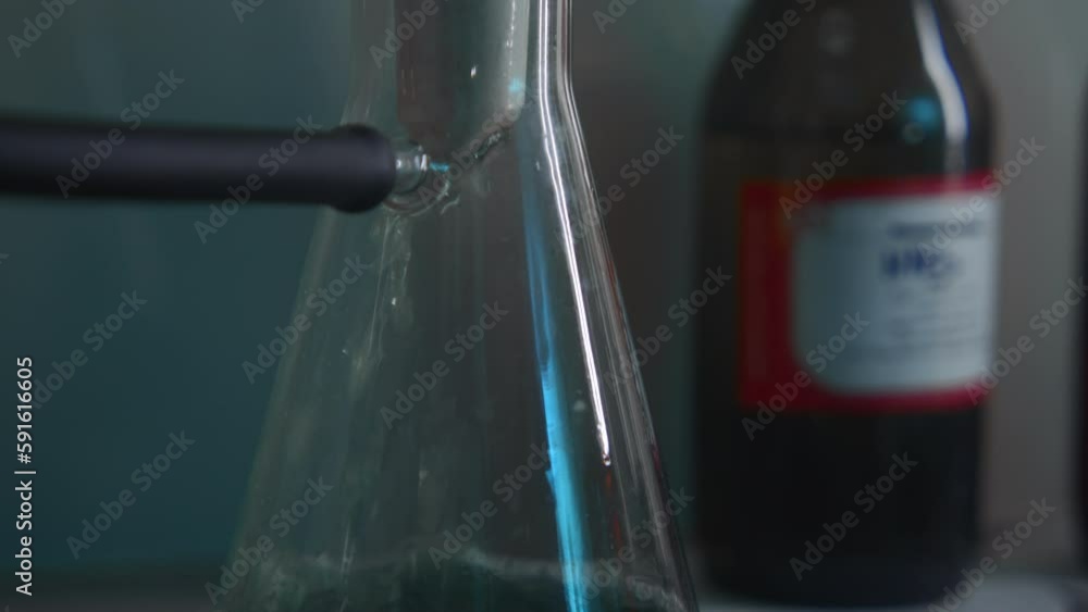 Poster close-up of chemical liquid is poured into flask. stock footage. flow of liquid filling laboratory f