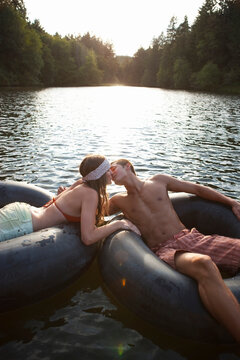 Young Couple Floating on Inner Tubes on the Lake, Near Portland, Oregon, USA