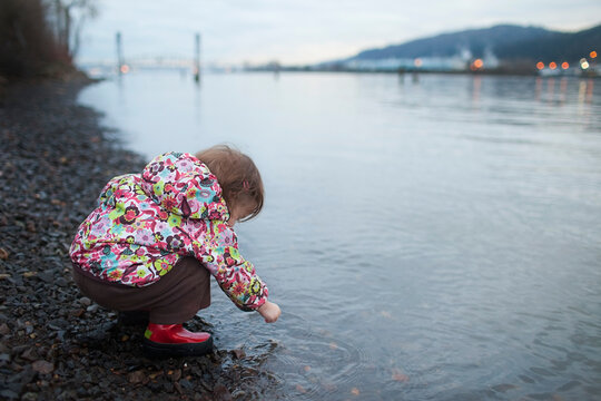 Young Girl Playing along Shoreline, Willamette River near Portland, Oregon, USA