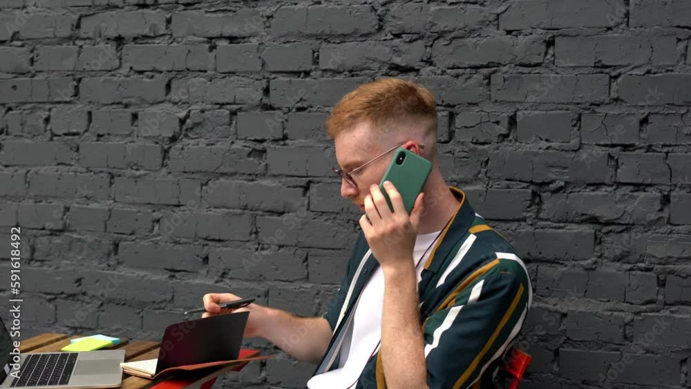 Poster caucasian male graphic designer planning startup project and creating web ideas while calling via mo