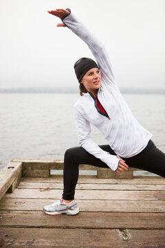 Woman Stretching on Dock before Jogging, Puget Sound, Seattle, Washington, USA